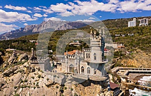 Castle Swallow`s Nest on a rock at Black Sea, Crimea. Castle is located in the urban area of Gaspra, Yalta. Aerial view
