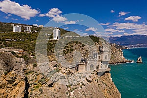 Castle Swallow`s Nest on a rock at Black Sea, Crimea. Castle is located in the urban area of Gaspra, Yalta. Aerial view