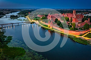 The Castle of the Teutonic Order in Malbork by the Nogat river at dusk. Poland photo