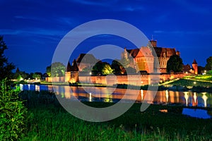 The Castle of the Teutonic Order in Malbork by the Nogat river at dusk. Poland photo