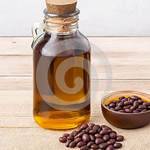 Castor beans and oil in a glass jar on wooden background