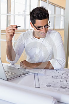 Casual architect working with laptop at desk