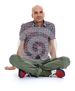 Casual bald man sitting with legs crossed