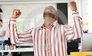 Casual black man celebrating success at office