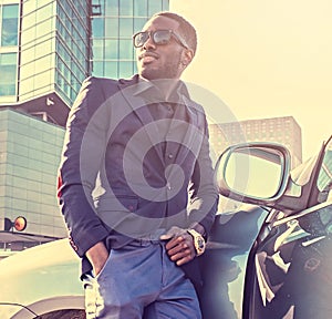 Casual black man posing near the car.