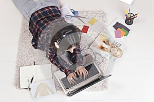 Casual blogger woman working with laptop in her fashion office.