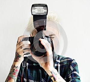 Casual blonde woman with tattoo holding camera taking a snap shot