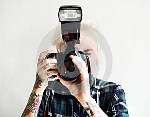 Casual blonde woman with tattoo holding camera taking a snap shot