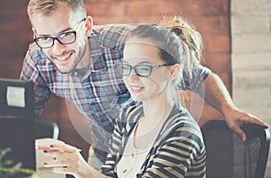 Casual business couple using computer in the office