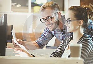 Casual business couple using computer in the office. Two colleagues working together