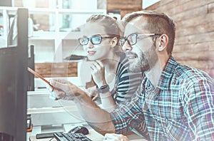 Casual business couple using computer in the office. Two colleagues working together on an innovative product design