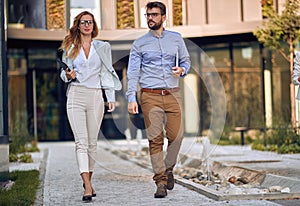 Casual business male and female colleagues going outiside