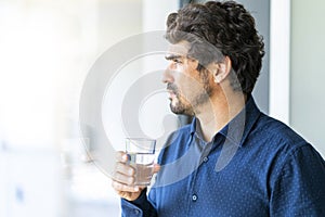 Casual business man holding and drinking glass of water