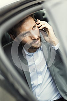 Casuale uomo d'affari sul telefono posteriore da auto 