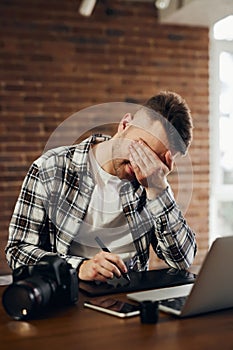 Casual business man with stylus pen writing on digital notepad, touching on digital tablet screen working on laptop computer in