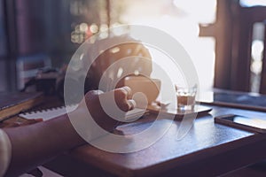 Casual Business man writing book with a phone and a camera on th