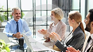 Casual business people around conference table in office