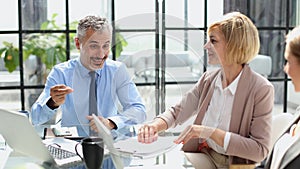 Casual business people around conference table in office