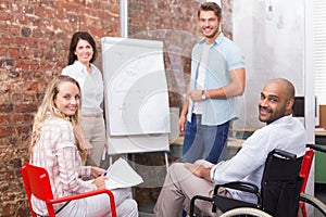 Casual business team having a meeting smiling at camera