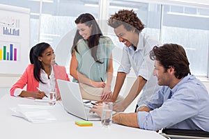 Casual business team having a meeting using laptop