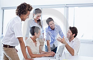 Casual business team having a meeting using laptop