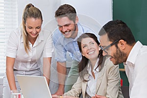 Casual business team having a meeting using laptop