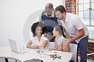 Casual business team having a meeting using laptop