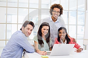 Casual business team smiling at camera during meeting