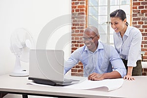 Casual business team using laptop at desk