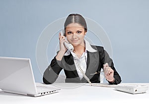 Casual business woman in office talking by phone