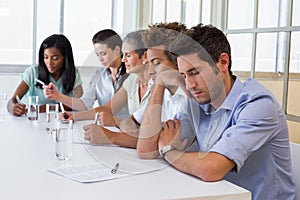 Casual businessman falling asleep during meeting