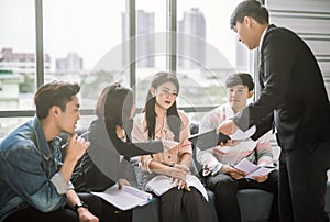 Casual businessman having business meeting with his staff. showing presentation on tablet.