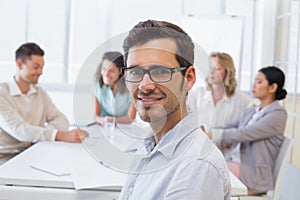 Casual businessman smiling at camera during meeting