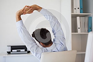 Casual businessman stretching in swivel chair