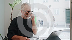 Casual businessman talking mobile phone in cafe closeup. Small business owner