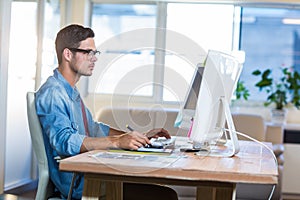 Casual businessman using digitizer at his desk