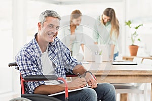 Casual businessman in wheelchair with notepad