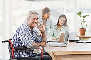 Casual businessman in wheelchair phoning