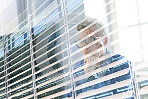 Casual businessman working in office, sitting at desk, typing on keyboard, looking at computer screen.