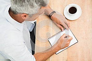 Casual businessman writing on notepad