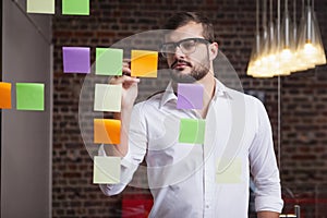 Casual businessman writing on sticky notes