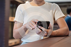 Casual Businesswoman holding and using smartphone for sms messages, young woman typing touchscreen mobile phone in cafe or modern