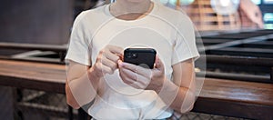 Casual Businesswoman holding and using smartphone for sms messages, young woman typing touchscreen mobile phone in cafe or modern