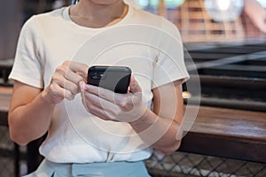 Casual Businesswoman holding and using smartphone for sms messages, young woman typing touchscreen mobile phone in cafe or modern