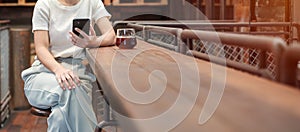 Casual Businesswoman holding and using smartphone for sms messages, young woman typing touchscreen mobile phone in coffee cafe or