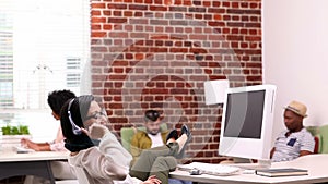 Casual businesswoman sitting with feet up at her desk