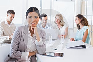 Casual businesswoman smiling at camera during meeting