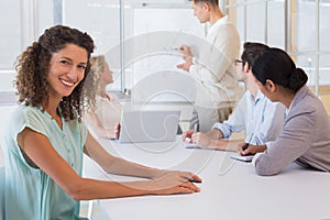 Casual businesswoman smiling at camera during meeting