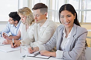 Casual businesswoman smiling at camera during meeting