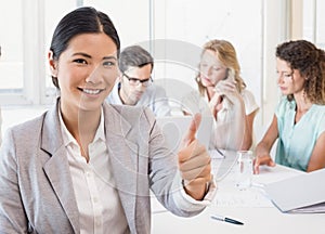 Casual businesswoman smiling at camera during meeting